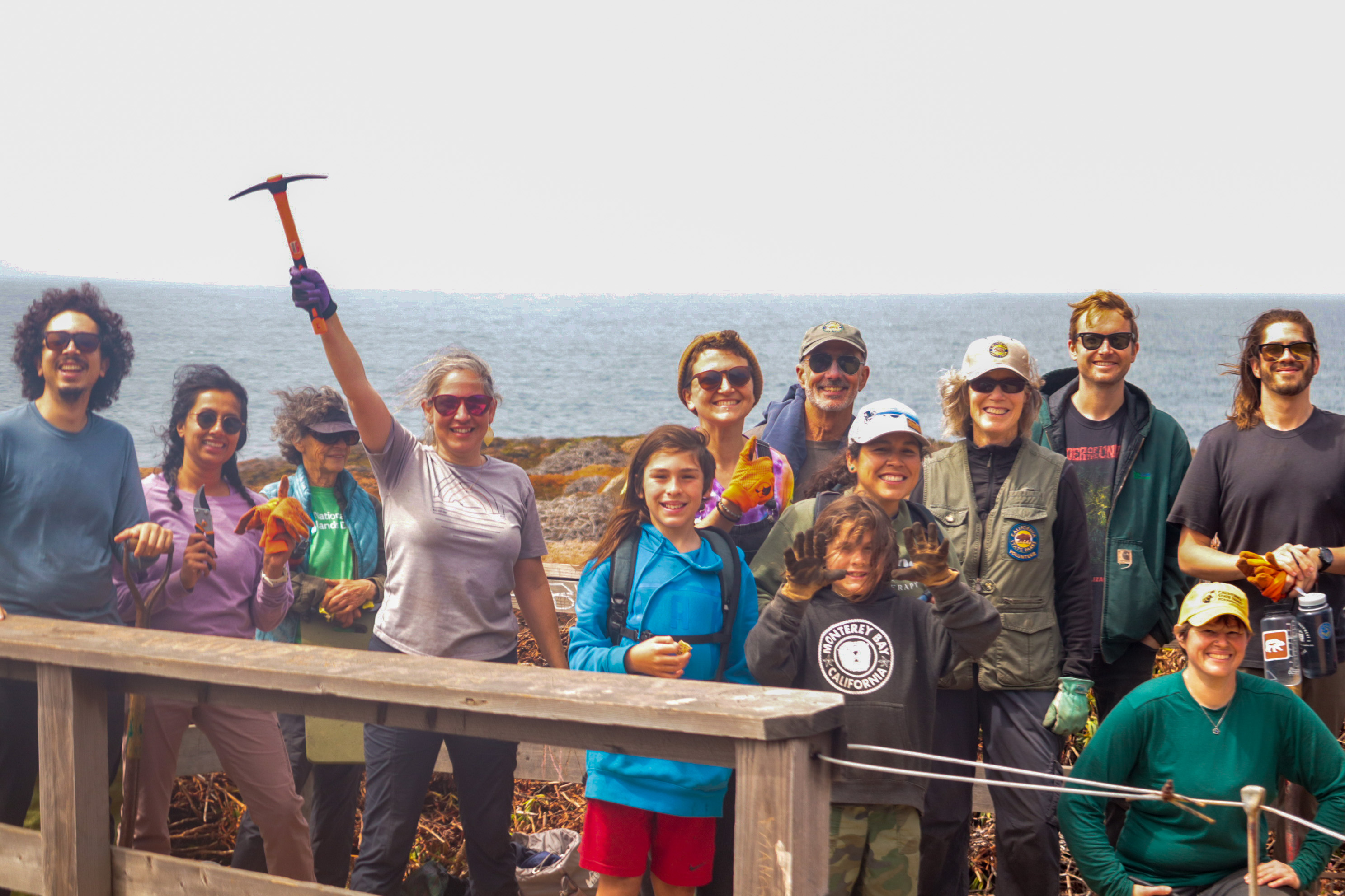 Volunteers pose in front of the bluffs at Garrapata State Park.
