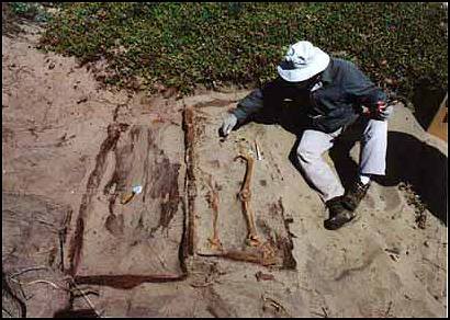 Peter Schulz next to exposed burial sites.
